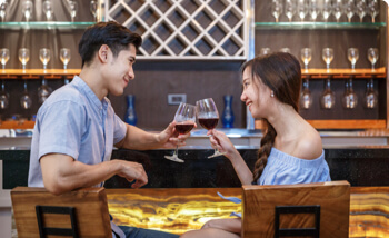 Smiling Singapore single man and woman enjoying drinks on a date